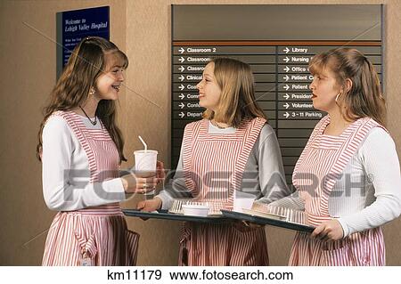 Stock Photo - Three Teenage Hospital Volunteers Two Holding Trays One With Soda Cup . Fotosearch