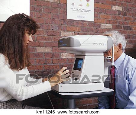 Stock Photograph - Woman Optometry Technician Giving Eye Test To Older Man . Fotosearch
