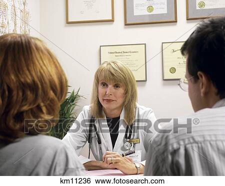 Stock Photograph - Woman Physician With Two Patients In Office . Fotosearch