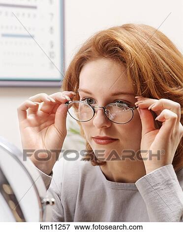 Stock Photo - Woman Trying On New Glasses . Fotosearch