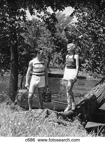 1930S Couple Man Woman Walking By River And Canoe Man Holding Thermos And Picnic Basket View Large Photo Image Stock Photograph - 1930S Couple Man Woman Walking By River And Canoe Man Holding Thermos And Picnic Basket. Fotosearch