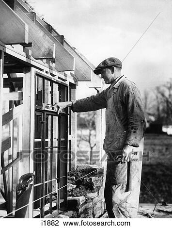 1930S Man Carpenter At Construction Site Wood Framed Building Holding Checking Level Installing Window Frame View Large Photo Image Stock Image - 1930S Man Carpenter At Construction Site Wood Framed Building Holding Checking Level Installing Window Frame . Fotosearch