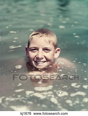 1940S 1950S Smiling Boy Swimming Up To Neck In Water Looking At Camera View Large Photo Image Stock Photograph - 1940S 1950S Smiling Boy Swimming Up To Neck In Water Looking At Camera. Fotosearch