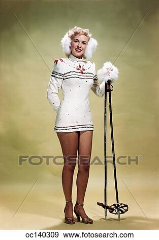 1940s smiling dress pinup christmas ski sweater wearing camera blonde woman earmuffs poles holding looking fotosearch