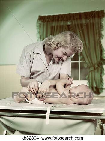 1950S Blond Woman Mother Diapering Baby With Cloth Diaper View Large Photo Image Picture - 1950S Blond Woman Mother Diapering Baby With Cloth Diaper. Fotosearch