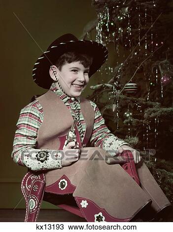 1950S Smiiling Boy Cowboy Hat Costume Holding Toy Gun By Christmas Tree View Large Photo Image Stock Image - 1950S Smiiling Boy Cowboy Hat Costume Holding Toy Gun By Christmas Tree . Fotosearch
