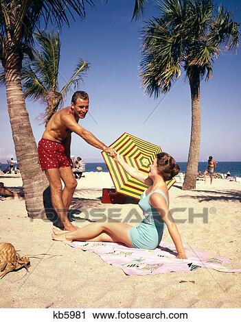 Stock Image - 1960S 1950S Couple On Tropical Beach. Fotosearch