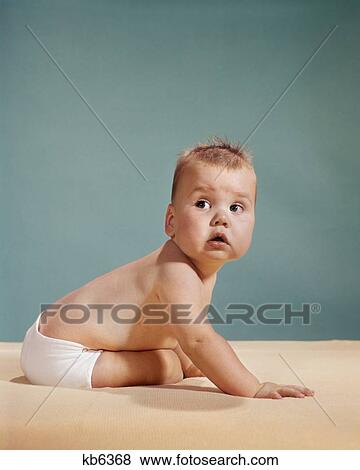 1960S 1970S Baby Looking Over Shoulder About To Crawl Away View Large Photo Image Stock Photo - 1960S 1970S Baby Looking Over Shoulder About To Crawl Away. Fotosearch