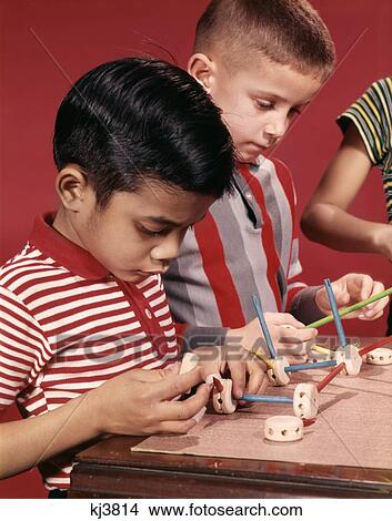 Picture - 1960S 1970S Hispanic And Caucasian Boys Playing With Tinker Toys . Fotosearch