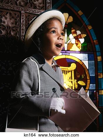 Picture - 1960S African American Girl In Church By Stained Glass Window Holding Booklet Singing Hymn . Fotosearch