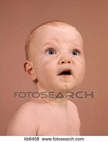 Stock Photo - 1960S Baby Portrait Looking Up Uncertain Facial Expression. Fotosearch