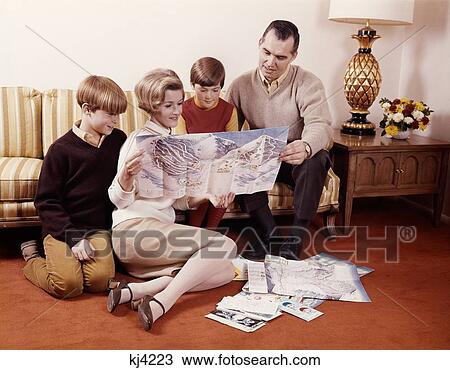 1960S Family Mother Father Son Daughter Sitting On Couch Reading Travel Map Planning Vacation View Large Photo Image Stock Image - 1960S Family Mother Father Son Daughter Sitting On Couch Reading Travel Map Planning Vacation . Fotosearch