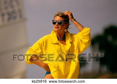 1980S Woman In Sunglasses Wearing Yellow Wind Breaker Jacket At Beach View Large Photo Image Stock Photograph - 1980S Woman In Sunglasses Wearing Yellow Wind Breaker Jacket At Beach. Fotosearch