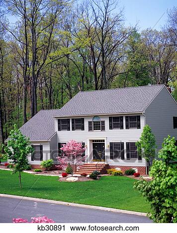 Stock Image - 1990S Center Hall Colonial Suburban Home In Spring. Fotosearch