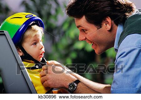 1990S Father Putting Son In Bike Seat Fastening His Helmet View Large Photo Image Stock Photograph - 1990S Father Putting Son In Bike Seat Fastening His Helmet. Fotosearch