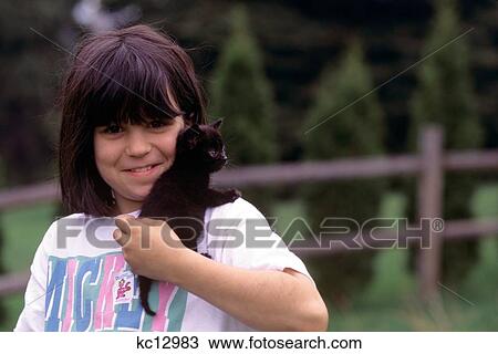 Stock Image - Smiling Girl With Black Kitten. Fotosearch