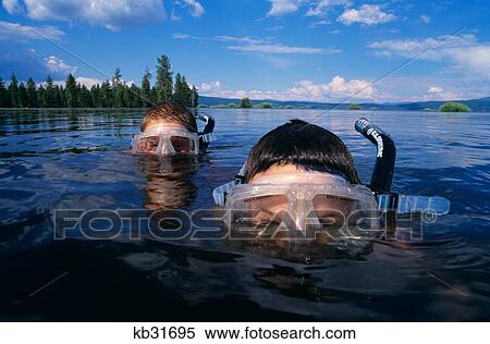 Two Boys Snorkeling In Mountain Lake Peering Over Water Looking At Camera View Large Photo Image Stock Photography - Two Boys Snorkeling In Mountain Lake Peering Over Water Looking At Camera. Fotosearch