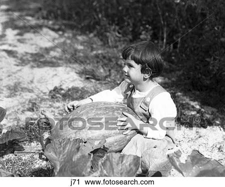 1920S 1930S Little Girl Sitting Holding Large Pumpkin View Large Photo Image Stock Image - 1920S 1930S Little Girl Sitting Holding Large Pumpkin. Fotosearch