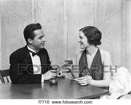 1930S 1940S Couple Drinking Toasting Club Table Smoking Cigarette Man Woman Men Women Couples Tuxedo Martini Restaurant Party View Large Photo Image Stock Image - 1930S 1940S Couple Drinking Toasting Club Table Smoking Cigarette Man Woman Men Women Couples Tuxedo Martini Restaurant Party. Fotosearch
