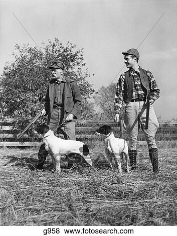 1930S 1940S Two Men Young & Senior Each With A Hunting Dog And Shot Gun Standing In A Field View Large Photo Image Stock Photo - 1930S 1940S Two Men Young & Senior Each With A Hunting Dog And Shot Gun Standing In A Field. Fotosearch