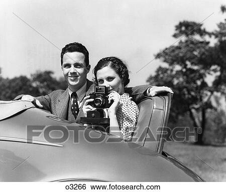 1930S Couple Sitting In Jump Seat Of Car Pointing Camera At Viewer View Large Photo Image Stock Photograph - 1930S Couple Sitting In Jump Seat Of Car Pointing Camera At Viewer. Fotosearch
