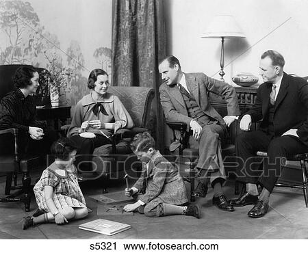 1930S Family In Living Room Boy Girl Playing On The Floor While Mother & Father Talk With Another Couple View Large Photo Image Stock Image - 1930S Family In Living Room Boy Girl Playing On The Floor While Mother & Father Talk With Another Couple. Fotosearch
