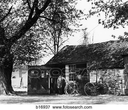 1930S Man Standing In Doorway Of Old Blacksmith'S Shop With Horse Carriage In Front View Large Photo Image Stock Photo - 1930S Man Standing In Doorway Of Old Blacksmith'S Shop With Horse Carriage In Front . Fotosearch