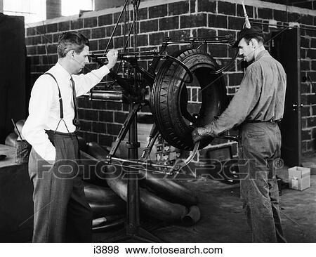 1940S 2 Men With Rubber Tire Machine Management Type Man In Suit Tie Other In Work Clothes View Large Photo Image Stock Photo - 1940S 2 Men With Rubber Tire Machine Management Type Man In Suit Tie Other In Work Clothes . Fotosearch