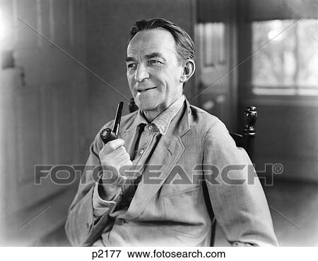 1940S Man Smiling Holding Smoking Tobacco Pipe Wearing Denim Shirt Work Jacket Sitting In Chair Rural Character Farmer View Large Photo Image Stock Photo - 1940S Man Smiling Holding Smoking Tobacco Pipe Wearing Denim Shirt Work Jacket Sitting In Chair Rural Character Farmer. Fotosearch
