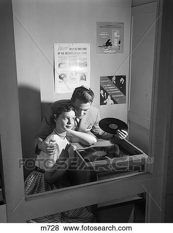 1950S Couple Sitting In Store Record Listening Booth Man With Arm Around Woman Holding 78 Rpm View Large Photo Image Stock Photo - 1950S Couple Sitting In Store Record Listening Booth Man With Arm Around Woman Holding 78 Rpm. Fotosearch