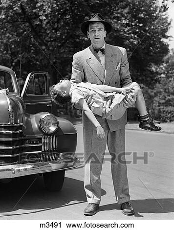 1950S Distraught Man Looking At Camera Carrying Unconscious And Injured Child That Was Hit By A Car View Large Photo Image Stock Image - 1950S Distraught Man Looking At Camera Carrying Unconscious And Injured Child That Was Hit By A Car. Fotosearch