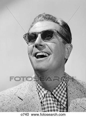 Stock Image - 1950S Man Wearing Sunglasses Smiling Looking Up. Fotosearch