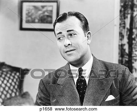 1950S Portrait Of Man Inside Living Room Wearing Suit And Tie Looking Off To One Side Thinking Contemplative Funny Expression View Large Photo Image Stock Photo - 1950S Portrait Of Man Inside Living Room Wearing Suit And Tie Looking Off To One Side Thinking Contemplative Funny Expression. Fotosearch