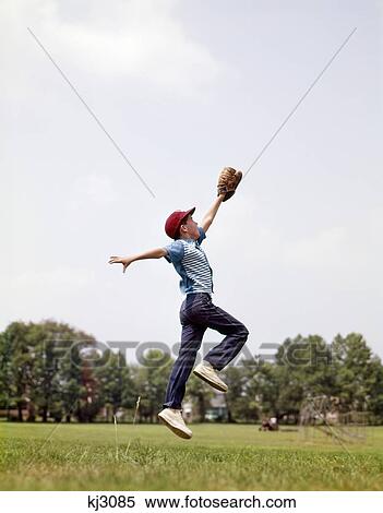 Stock Photography - 1960S Boy Jumping To Catch Fly Ball With Baseball Mitt. Fotosearch
