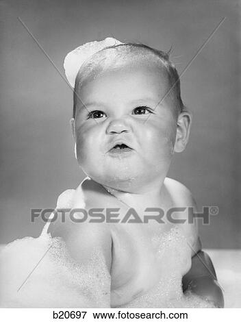 Stock Photo - 1960S Cute Pugnacious Baby In Bath Covered In Soap Suds. Fotosearch