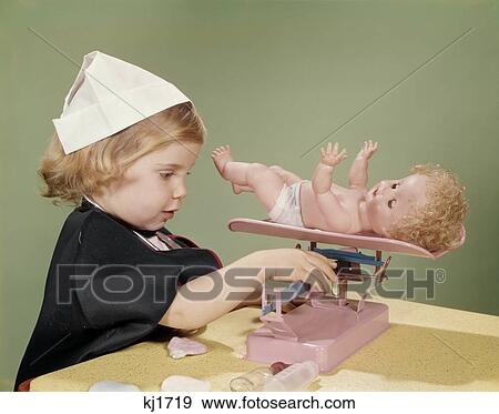 1960S Little Girl Dressed In Nurse'S Costume Weighing Her Doll On Toy Baby Scale View Large Photo Image Stock Photo - 1960S Little Girl Dressed In Nurse'S Costume Weighing Her Doll On Toy Baby Scale. Fotosearch
