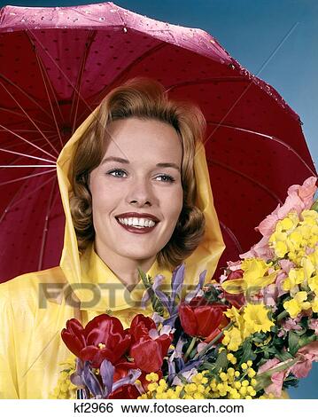 1960S Smiling Woman Under Red Umbrella Yellow Raincoat Holding Spring Flowers View Large Photo Image Stock Photograph - 1960S Smiling Woman Under Red Umbrella Yellow Raincoat Holding Spring Flowers . Fotosearch