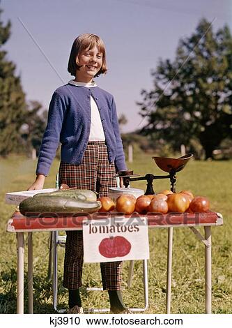1960S Smiling Young Teenage Girl At Folding Table Roadside Farm Stand Selling Fresh Zucchini And Tomatoes View Large Photo Image Stock Image - 1960S Smiling Young Teenage Girl At Folding Table Roadside Farm Stand Selling Fresh Zucchini And Tomatoes. Fotosearch