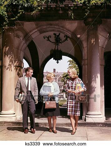 1960S Three Students Walking On Campus Carrying Books Talking Smiling View Large Photo Image Stock Photo - 1960S Three Students Walking On Campus Carrying Books Talking Smiling . Fotosearch