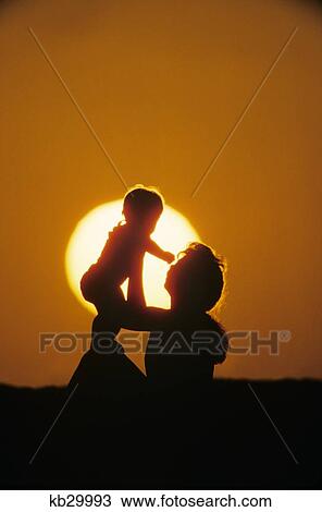 Anonymous Silhouetted Mother Holding Baby Up In The Air At Sunset View Large Photo Image Stock Image - Anonymous Silhouetted Mother Holding Baby Up In The Air At Sunset. Fotosearch