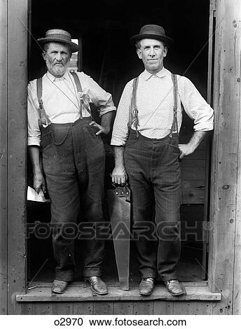 1890S 1895 Portrait Of Two Workmen Standing In Open Doorway Holding Carpenter Tools Looking At Camera View Large Photo Image Stock Image - 1890S 1895 Portrait Of Two Workmen Standing In Open Doorway Holding Carpenter Tools Looking At Camera . Fotosearch