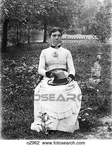 1890S 1900S Portrait Woman Wearing Striped Dress Sitting In Chair In Garden Holding Hat In Lap View Large Photo Image Stock Image - 1890S 1900S Portrait Woman Wearing Striped Dress Sitting In Chair In Garden Holding Hat In Lap. Fotosearch