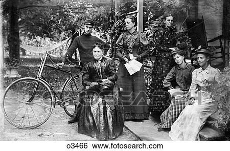 1890s GROUP PORTRAIT FIVE WOMEN ONE MAN STANDING BY BICYCLE POSING ON FRONT PORCH OF HOUSE LOOKING AT CAMERA View Large Photo Image Stock Photograph - 1890s GROUP PORTRAIT FIVE WOMEN ONE MAN STANDING BY BICYCLE POSING ON FRONT PORCH OF HOUSE LOOKING AT CAMERA. Fotosearch