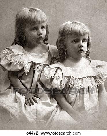 1890s PORTRAIT TURN OF THE 20TH CENTURY TWIN GIRLS SISTERS WEARING IDENTICAL DRESSES AND SHOWING MOROSE SAD FACIAL EXPRESSIONS View Large Photo Image Stock Image - 1890s PORTRAIT TURN OF THE 20TH CENTURY TWIN GIRLS SISTERS WEARING IDENTICAL DRESSES AND SHOWING MOROSE SAD FACIAL EXPRESSIONS. Fotosearch