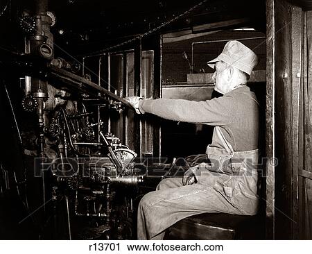 1920s 1930s 1940s PROFILE MAN TRAIN ENGINEER AT CONTROLS IN LOCOMOTIVE CAB OF RAILROAD STEAM ENGINE View Large Photo Image Stock Image - 1920s 1930s 1940s PROFILE MAN TRAIN ENGINEER AT CONTROLS IN LOCOMOTIVE CAB OF RAILROAD STEAM ENGINE. Fotosearch
