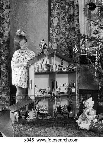 1920S 1930S Smiling Little Girl With Large Dollhouse And Christmas Tree View Large Photo Image Stock Photography - 1920S 1930S Smiling Little Girl With Large Dollhouse And Christmas Tree. Fotosearch