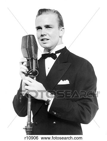 1920s 1930s SMILING MAN RADIO SINGER ENTERTAINER CROONER IN TUXEDO SINGING INTO MICROPHONE View Large Photo Image Stock Photograph - 1920s 1930s SMILING MAN RADIO SINGER ENTERTAINER CROONER IN TUXEDO SINGING INTO MICROPHONE. Fotosearch