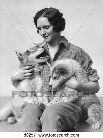 1920S 1930S Smiling Woman Holding Two Husky Puppies In Her Lap View Large Photo Image Stock Photo - 1920S 1930S Smiling Woman Holding Two Husky Puppies In Her Lap. Fotosearch