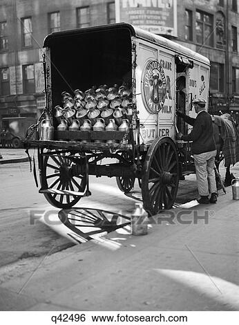 Stock Photograph - 1920S Milkman Reaching Into Side Of Horse-Drawn Delivery Wagon. Fotosearch