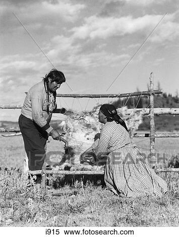 Stock Photography - 1920S Native American Couple Man Woman Treating Animal Hide Skin Stoney Sioux Alberta Canada . Fotosearch